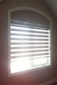 an empty room with a window covered in blinds