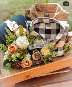 a wooden table topped with lots of different types of flowers and clothing on top of it