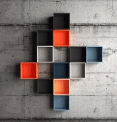 an abstract design made out of cubes on the wall with concrete floor and walls behind it