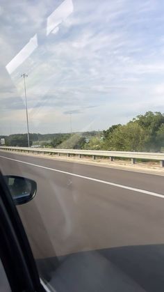 a car driving down the highway with trees in the background