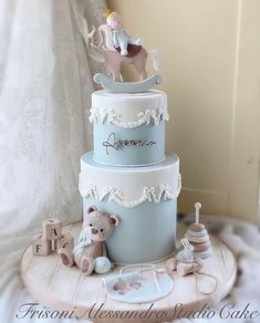 a three tiered cake with an elephant and horse decoration on the top, sitting on a table