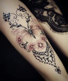 two tattoos with flowers and butterflies on their legs, one is black and the other is white