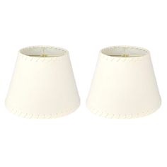 two white lampshades sitting next to each other on a white background, one has a light bulb in the middle