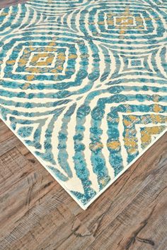 a blue and yellow area rug on top of a wooden floor next to a wood floor