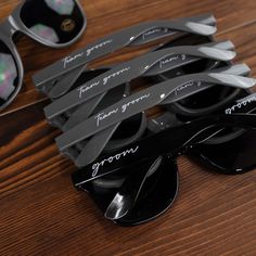 several pairs of sunglasses sitting on top of a wooden table next to each other with writing on them