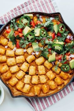 a dish with tofu, avocado and cilantro in it on a table