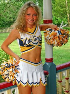 a cheerleader standing next to a pole with her hands on her hips