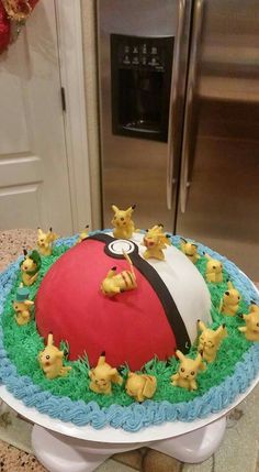 a pokemon themed cake with pikachu figurines around it on a table