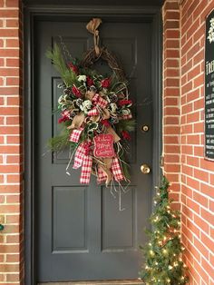 the front door is decorated with christmas wreaths