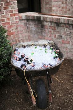 a wheelbarrow filled with lots of beer bottles in the middle of a yard