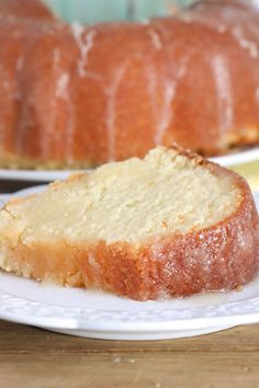 a loaf of lemon pound cake on a white plate next to a slice of lemon pound cake