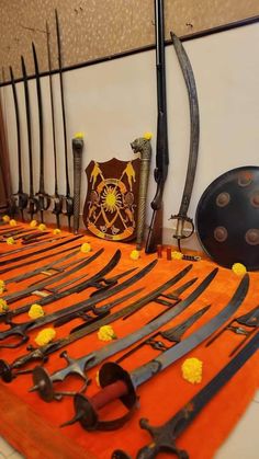 a table topped with lots of different types of swords and knives next to each other