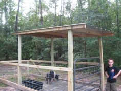 a young boy standing in front of an animal pen