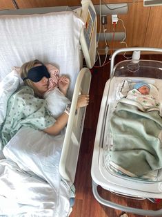 a woman laying in a hospital bed next to a baby