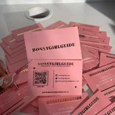 a pile of pink business cards sitting on top of a table