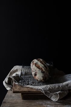 a loaf of bread sitting on top of a wooden table next to a cooling rack