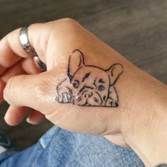 a hand with a small dog tattoo on it's left wrist and the outline of a puppy