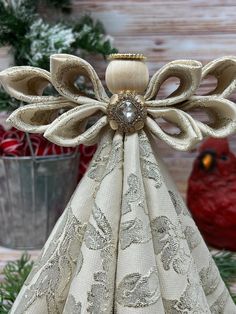 an angel made out of fabric sitting on top of a table next to christmas decorations