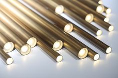 several different types of metal tubes on a white surface with light coming from the top