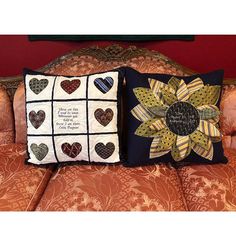 two pillows with hearts on them sitting on a couch