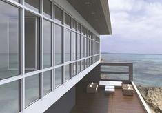 a balcony overlooking the ocean with lots of windows