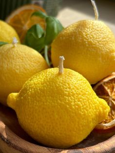 some lemons are sitting in a wooden bowl