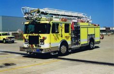 a yellow fire truck parked in an empty lot