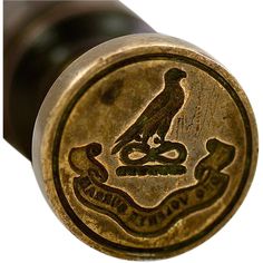 a close up view of the top of a brass bottle stopper with a bird on it