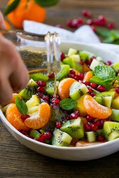 a bowl filled with sliced fruit and garnishes on top of a wooden table