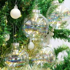 christmas ornaments hanging from the branches of a tree with lights and baubles on it