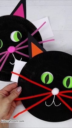 paper plate cat craft for kids with green eyes and black cat's head on it