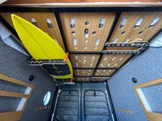 a yellow surfboard sitting in the middle of a room