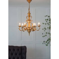 a chandelier hanging from the ceiling in a room with white walls and green plants