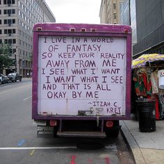 a pink truck with writing on the back