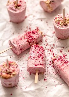 several popsicles that are covered in pink sprinkles and topped with toothpicks