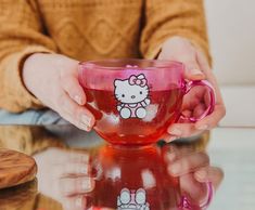 a person holding a hello kitty coffee cup