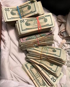 a pile of money sitting on top of a bed