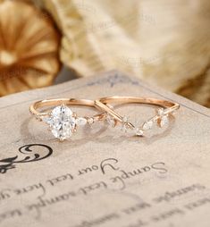 two wedding rings sitting on top of a piece of paper next to a ring box