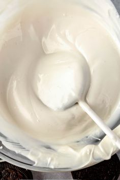 a bowl filled with white cream sitting on top of a table