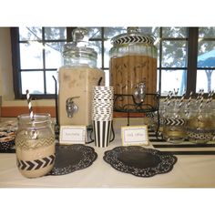 there is a table set up with mason jars and place settings for desserts or drinks