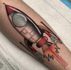 a tattoo with a rocket ship on it