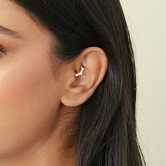 a close up of a person wearing a pair of ear piercings on their ears