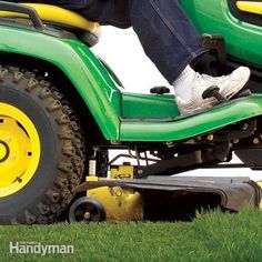 a man riding on the back of a green lawn mower