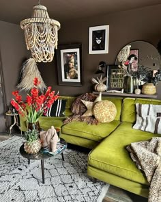 a living room filled with green couches and pictures on the wall above them,