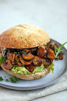 a sandwich with mushrooms and avocado on a plate