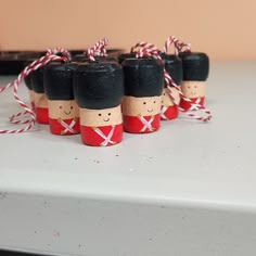 small wooden toy soldiers tied with red and white twine on top of a table