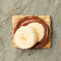 two slices of banana and peanut butter on crackers with melted chocolate in the middle