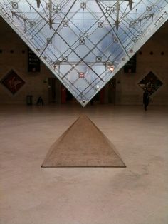 the inside of a building with a pyramid shaped sculpture