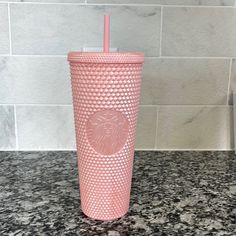 a pink starbucks cup sitting on top of a counter