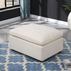 a white ottoman sitting on top of a blue rug